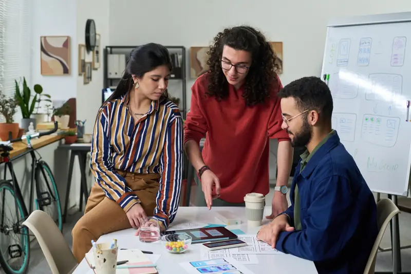 Equipe analisando protótipos de layout em uma reunião criativa
